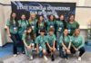 a group of girls in green shirts posing for a picture