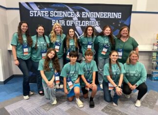 a group of girls in green shirts posing for a picture