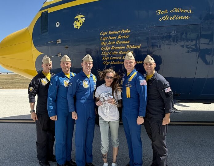 Nicole Navarro with Blue Angels a group of people standing in front of an airplane