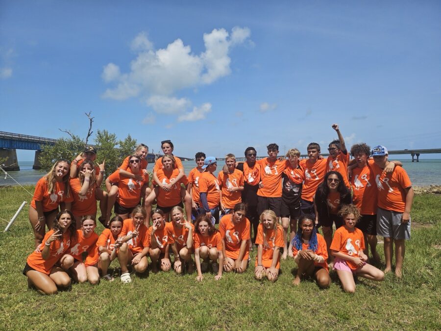 a group of people in orange shirts posing for a picture