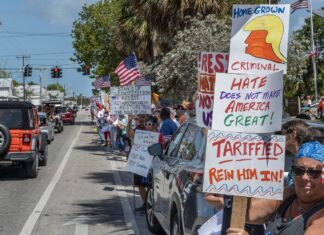 a group of people holding signs on the side of a road