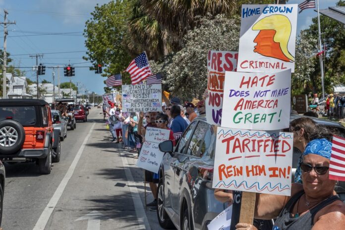 Patriots Day Protest KW 2025 NWM-2305 Large a group of people holding signs on the side of a road