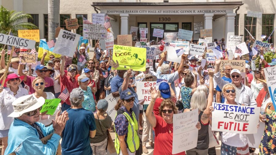 a large group of people holding signs in front of a building