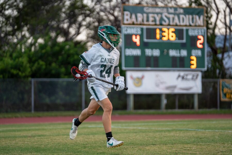 a lacrosse player running across a field