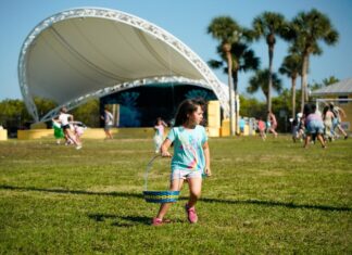 a little girl holding a frisbee in a field