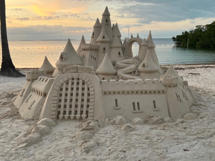a sand castle sitting on top of a sandy beach
