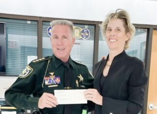 a man in a uniform holding a cheque