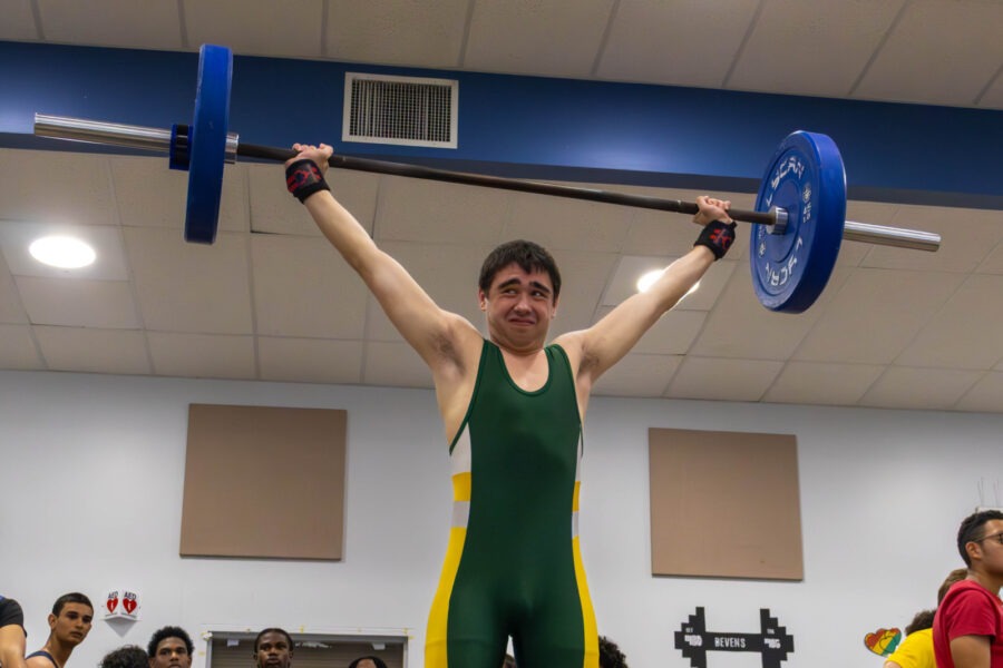 a man lifting a barbell in a gym