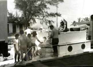 a black and white photo of a group of people on a boat