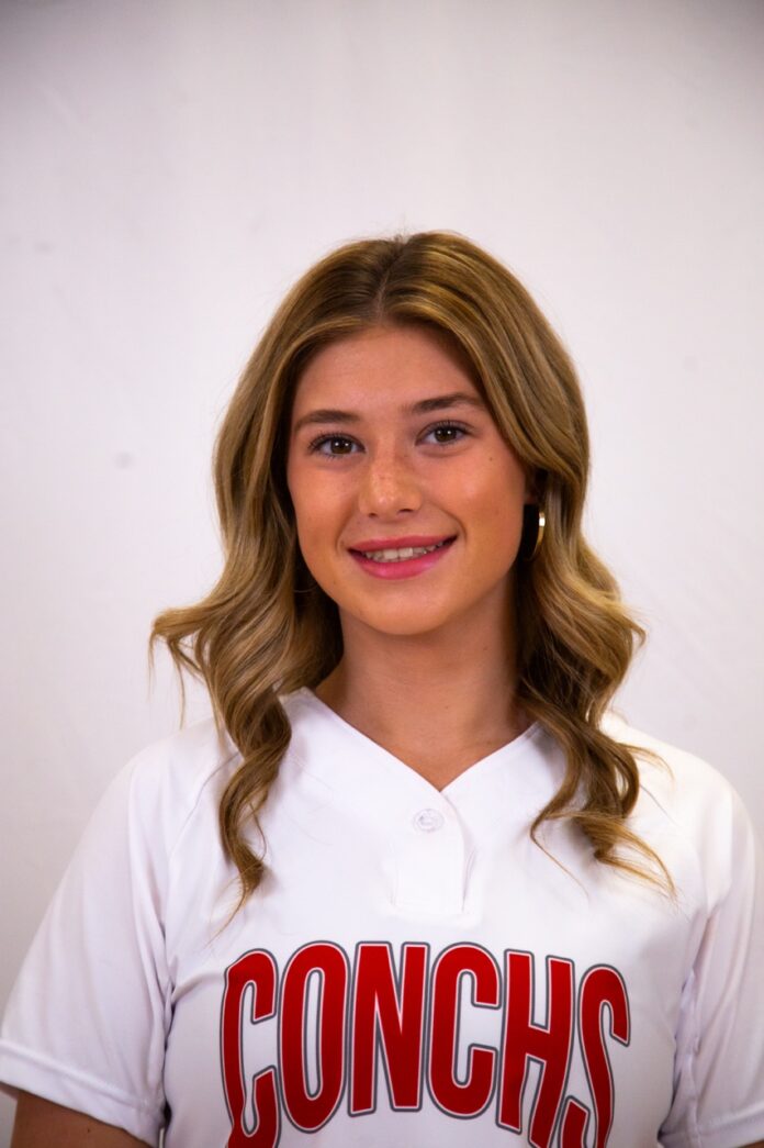 a woman in a baseball uniform posing for a picture