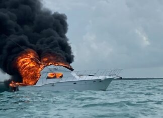 a boat in the water with a lot of black smoke coming out of it