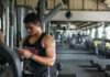 a man in a gym looking at his cell phone