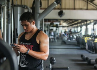 a man in a gym looking at his cell phone