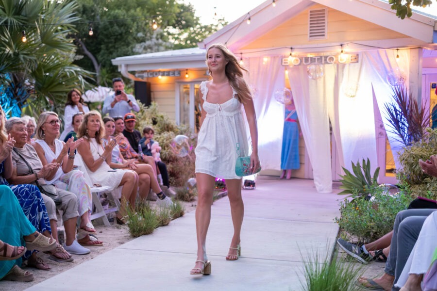 a woman walking down a runway in front of a crowd