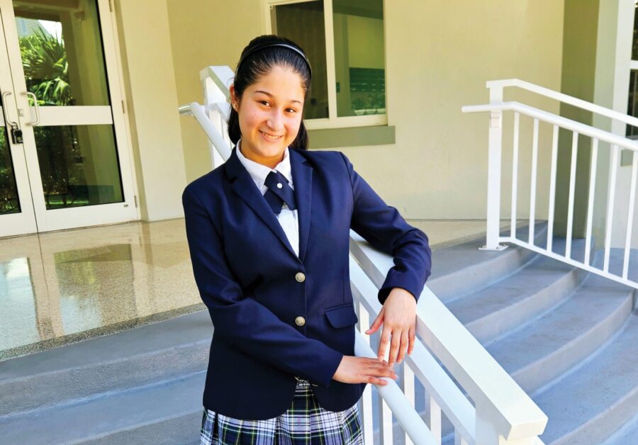 a girl in a school uniform standing on a porch