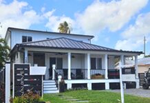a small white house with a black roof