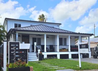a small white house with a black roof