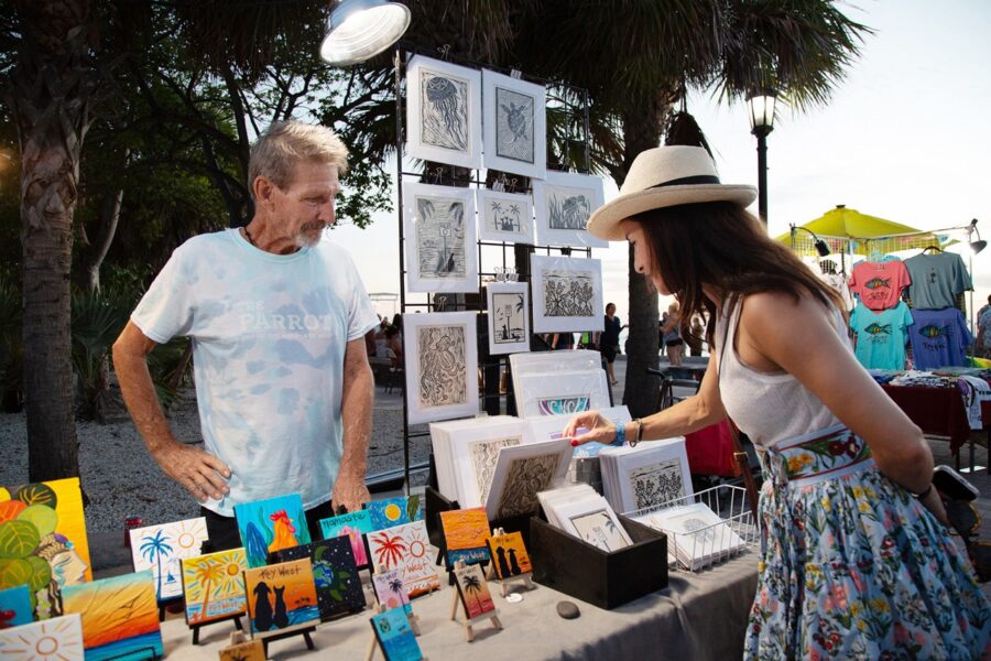 a man and a woman looking at art on a table