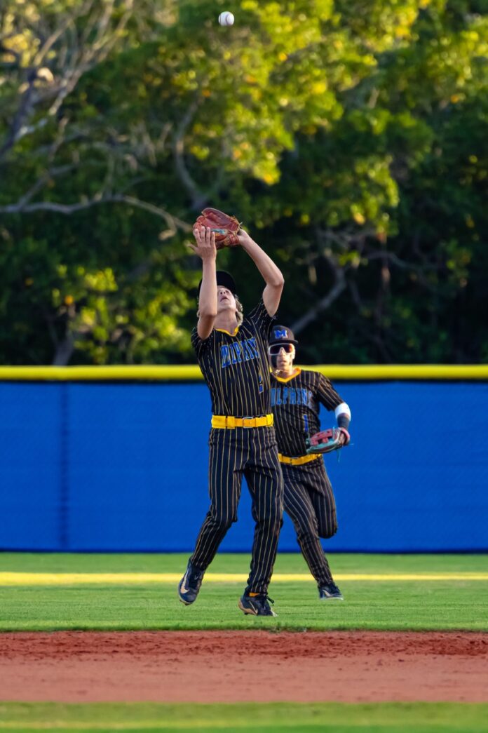 a couple of men standing on top of a baseball field