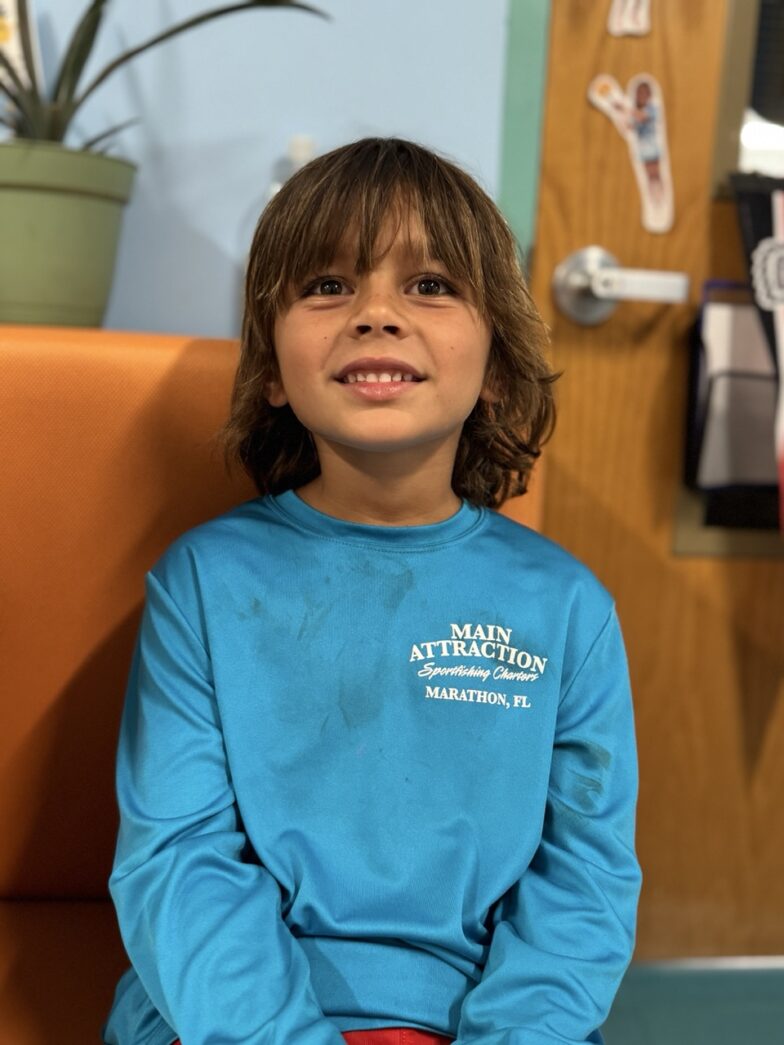 a young boy sitting on a chair in a room