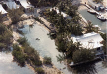 an aerial view of a house surrounded by water