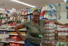 a woman standing in a store next to a computer