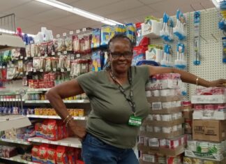 a woman standing in a store next to a computer