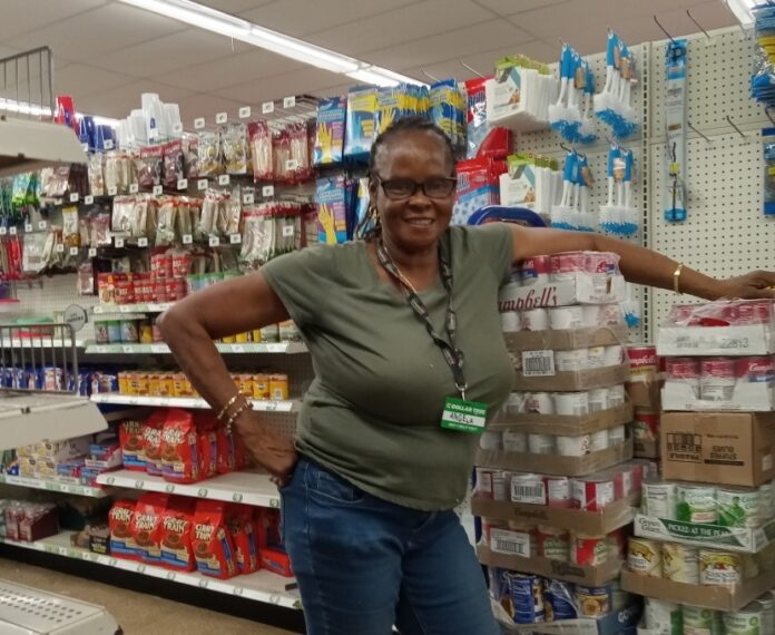 a woman standing in a store next to a computer