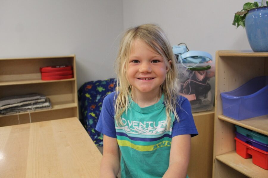 a little girl sitting on a chair in a room