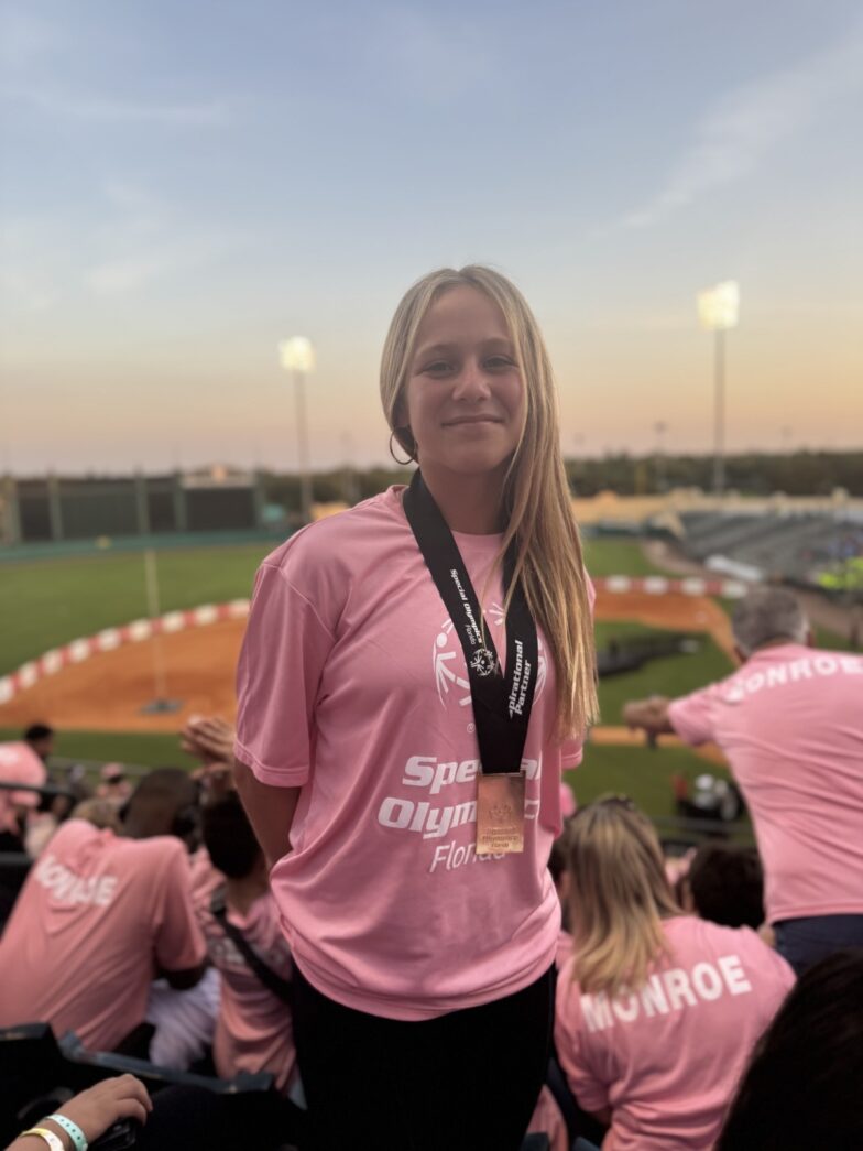 a woman in a pink shirt standing in front of a crowd