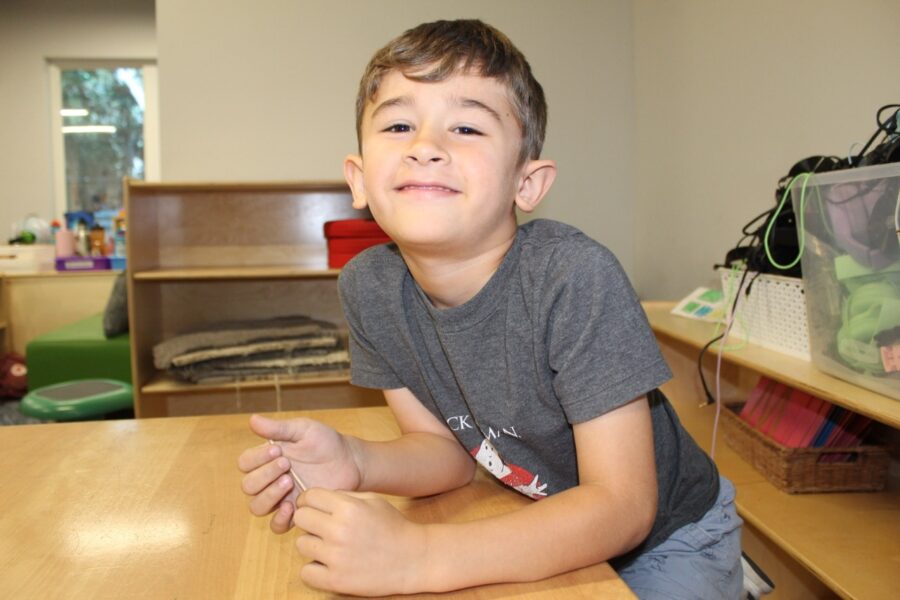 a young boy sitting at a table in a classroom