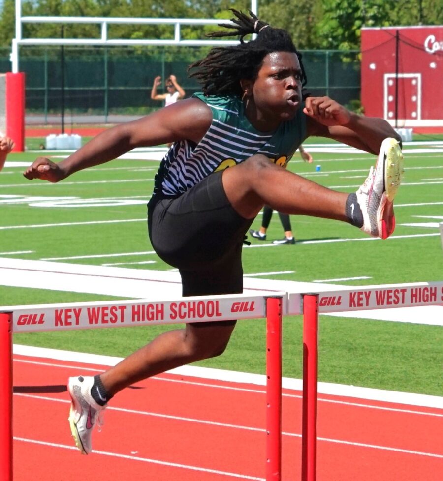 a person jumping over a hurdle on a track