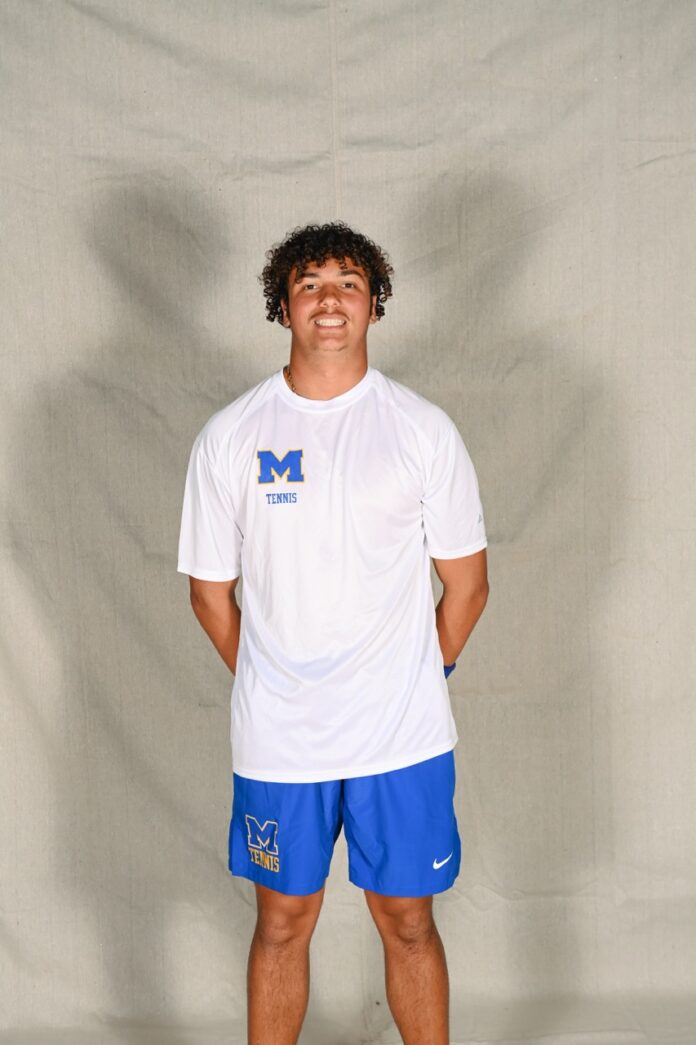 a man in a white shirt and blue shorts