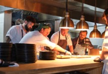 a group of men in a kitchen preparing food