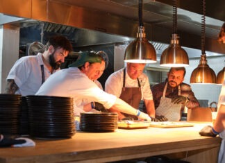 a group of men in a kitchen preparing food