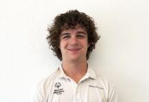 a man with curly hair wearing a white shirt