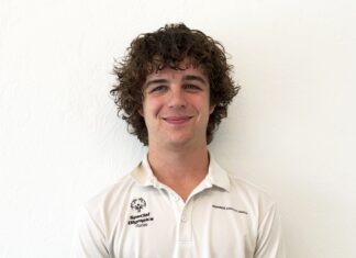 a man with curly hair wearing a white shirt