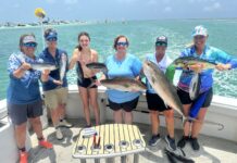 a group of people on a boat holding fish