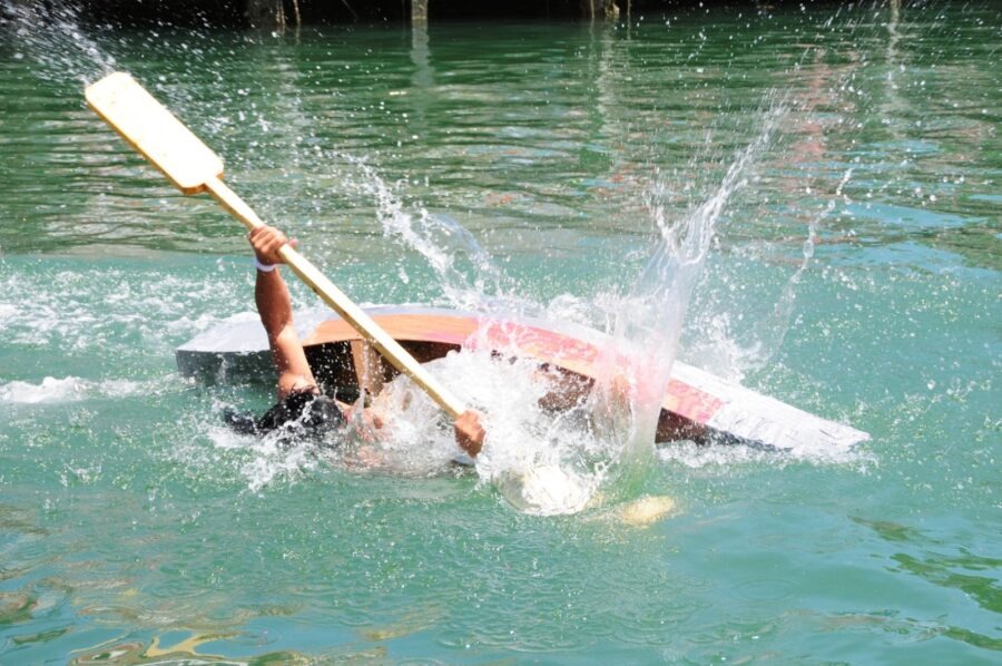 a person in a body of water with a paddle