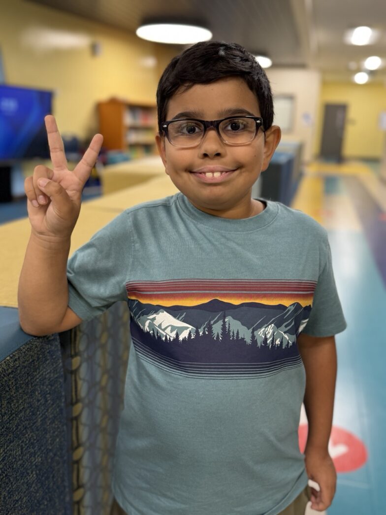 a young boy standing in front of a bowling alley