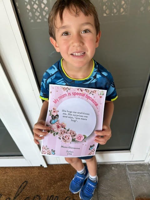 a young boy is holding up a book