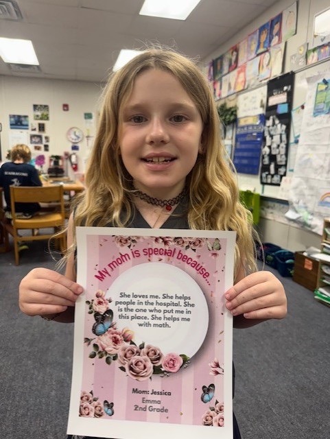 a young girl holding up a paper with a poem on it