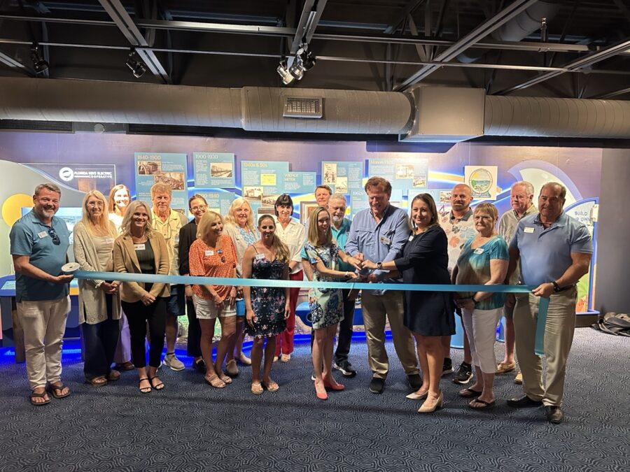 a group of people standing in front of a blue ribbon