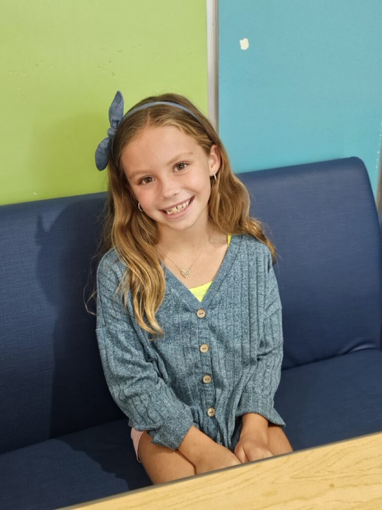a young girl sitting on a blue couch