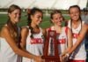 a group of girls standing next to each other holding a trophy