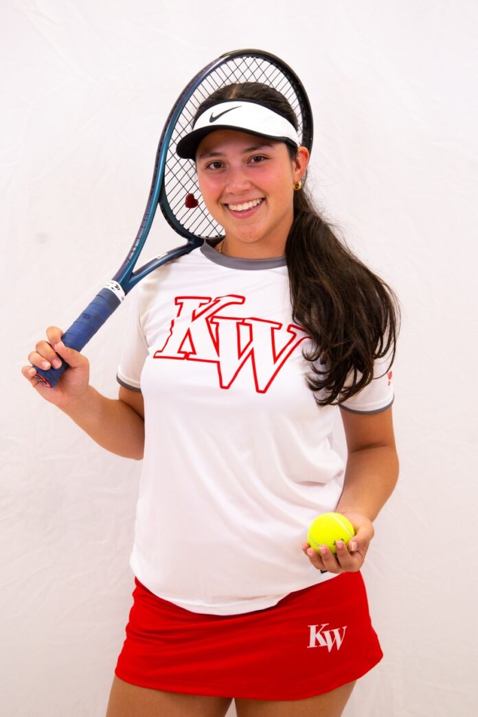 a woman holding a tennis racquet and a tennis ball