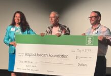 a group of people holding a large check