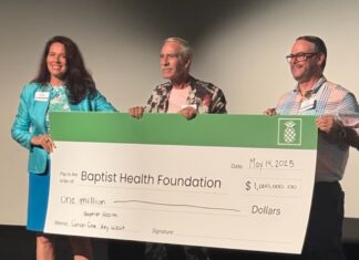 a group of people holding a large check