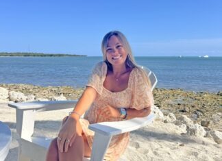 a woman sitting on a white chair on the beach
