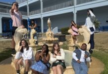 a group of people sitting on a bench in front of a building